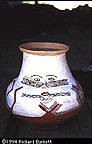 small kichwa pottery jar with a face painted on it